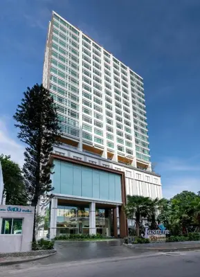 a tall building with a tree in front of it at Jasmine 59 Hotel in Bangkok