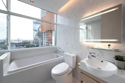 a white bathroom with a sink and a toilet and a tub at Jasmine 59 Hotel in Bangkok