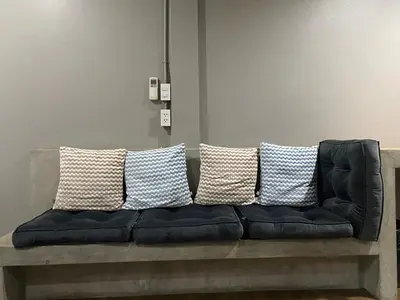 a black couch with several pillows on it at Yaksa Private in Bangkok