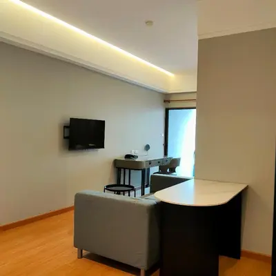 a living room with a couch and a table at Boss Hotel in Bangkok