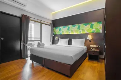 a bedroom with a large bed and a large window at Boss Hotel in Bangkok