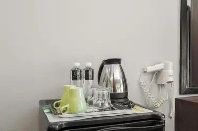 a counter with a coffee maker and glasses on it at Boss Hotel in Bangkok