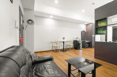 a living room with a leather couch and a table at Boss Hotel in Bangkok