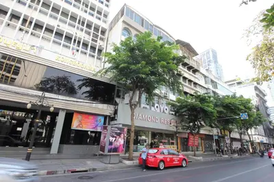 a red car parked on the side of a city street at Diamond Residence Silom in Bangkok