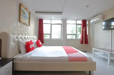 a bedroom with a large bed with red pillows at Diamond Residence Silom in Bangkok
