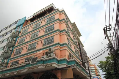 a tall pink building with a lot of windows at Bourbon St. Boutique Hotel in Bangkok