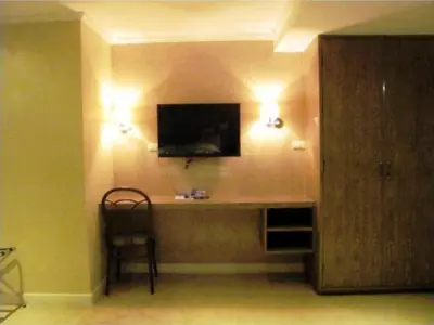 a room with a desk with a television and a chair at Bourbon St. Boutique Hotel in Bangkok