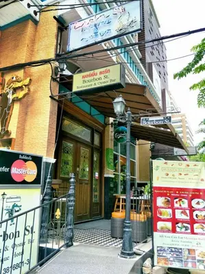 a street sign in front of a building at Bourbon St. Boutique Hotel in Bangkok
