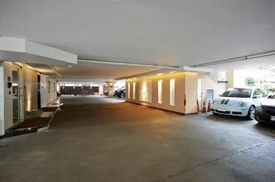 an empty garage with two cars parked in it at Ravipha Residences in Bangkok