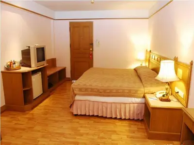 a hotel room with a bed and a television at Silom Village Inn in Bangkok