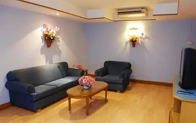 a living room with a couch and a table with flowers on the wall at Silom Village Inn in Bangkok