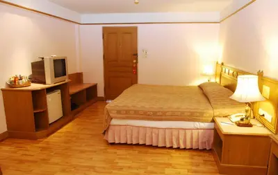 a hotel room with a bed and a television at Silom Village Inn in Bangkok
