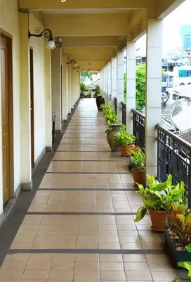 an empty hallway of a building with plants at Silom Village Inn in Bangkok