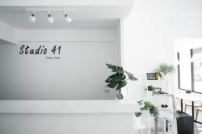 a white room with plants and a sign on the wall at Studio 41 Salaya-Sai4 in Nakhon Pathom