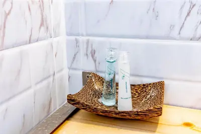 a toothbrush and a bottle on a basket in a bathroom at Living Naraa Place in Bangkok