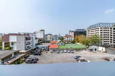 a parking lot with cars parked in a city at Living Naraa Place in Bangkok