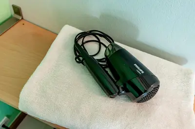 a green appliance sitting on top of a towel at Living Naraa Place in Bangkok