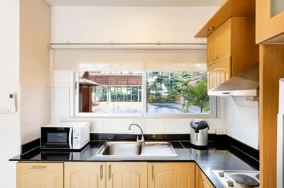 a kitchen with a sink and a microwave at Teja Hotel in Bangkok