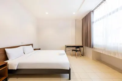 a bedroom with a white bed and a window at Teja Hotel in Bangkok