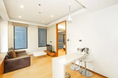 a kitchen and living room with a couch and a table at Marvin Suites Hotel in Bangkok