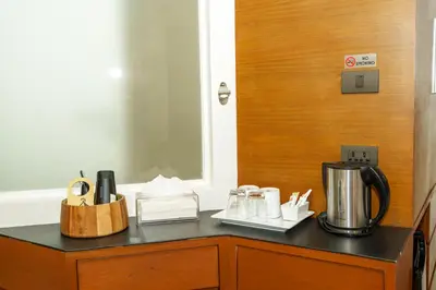 a counter top with a coffee maker on it at Marvin Suites Hotel in Bangkok