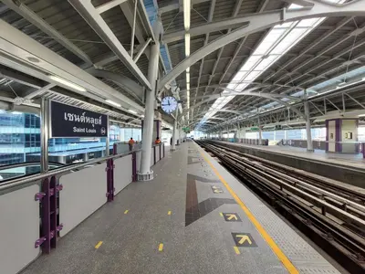 a train station with a platform and a train at Marvin Suites Hotel in Bangkok
