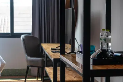 a desk with a computer and a chair in a room at W22 by Burasari in Bangkok