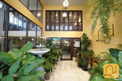a lobby with plants and a fountain in a building at Na Vayla PaPlern in Bangkok