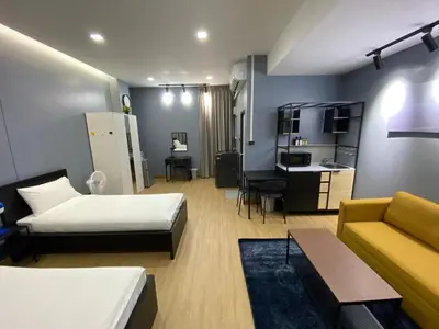 a bedroom with a bed and a couch and a kitchen at Bangyai Inn-private room in Nonthaburi