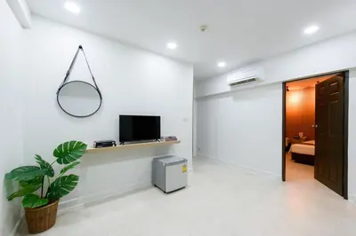 a living room with a tv and a potted plant at Grand Watergate Hotel in Bangkok