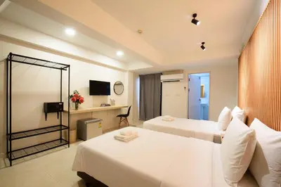a hotel room with two beds and a television at Grand Watergate Hotel in Bangkok