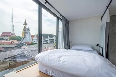 a bedroom with a bed and a large window at Lost Inn BKK in Bangkok