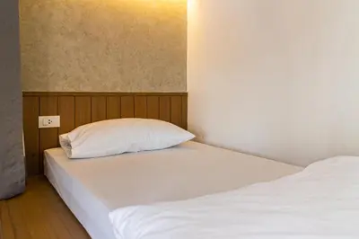 a bedroom with two beds and a white pillow at Lost Inn BKK in Bangkok