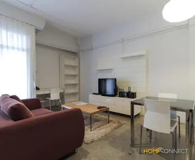 a living room with a couch and a table at T Series Place Serviced Apartment in Bangkok