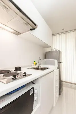 a white kitchen with a sink and a refrigerator at The Cube Residence Government Complex Laksi in Lak Si