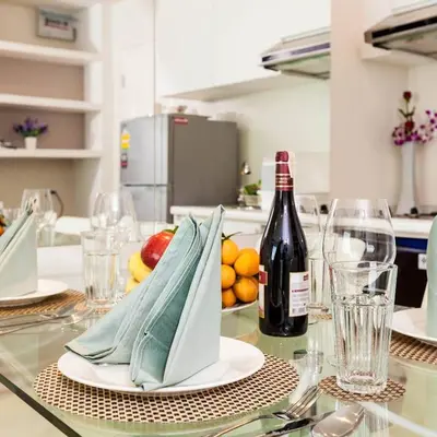 a table with a bottle of wine and a plate of fruit at The Cube Residence Government Complex Laksi in Lak Si