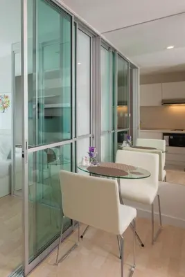 a living room with a table and white chairs at The Cube Residence Government Complex Laksi in Lak Si