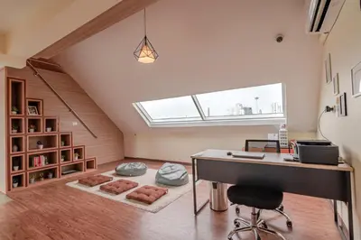 an attic office with a desk and a window at The Victory View in Bangkok