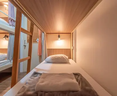 a bed in a small room with a window at The Victory View in Bangkok