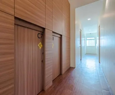 a hallway with a door with a sign on it at The Victory View in Bangkok