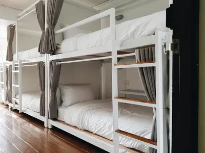 two bunk beds in a room with white furniture at LITA Bangkok in Bangkok