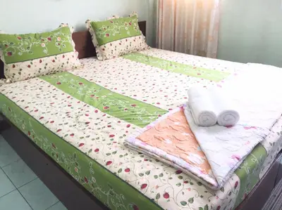 a bed with towels and pillows on it at NAT 2 Guest House in Bangkok