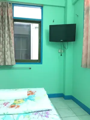 a bedroom with a bed and a tv on the wall at NAT 2 Guest House in Bangkok