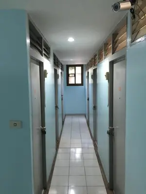 a hallway with blue doors and a tile floor at NAT 2 Guest House in Bangkok