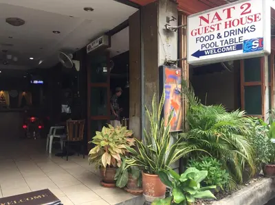 a restaurant with plants and a sign on the front of it at NAT 2 Guest House in Bangkok