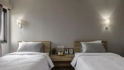 two beds sitting next to each other in a bedroom at Carnation Residence in Samut Prakan