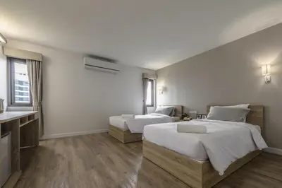 a hotel room with two beds and a sink at Carnation Residence in Samut Prakan