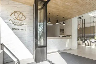 a lobby of a restaurant with a sign on the wall at Carnation Residence in Samut Prakan