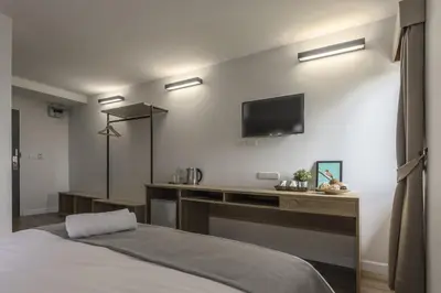 a bedroom with a bed and a tv on the wall at Carnation Residence in Samut Prakan