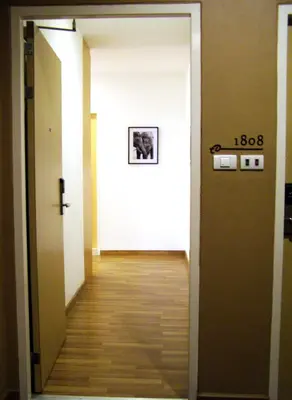 a hallway with a door open to a hallway with aoice at Iyarin @ Tuk Chang Hotel in Bangkok